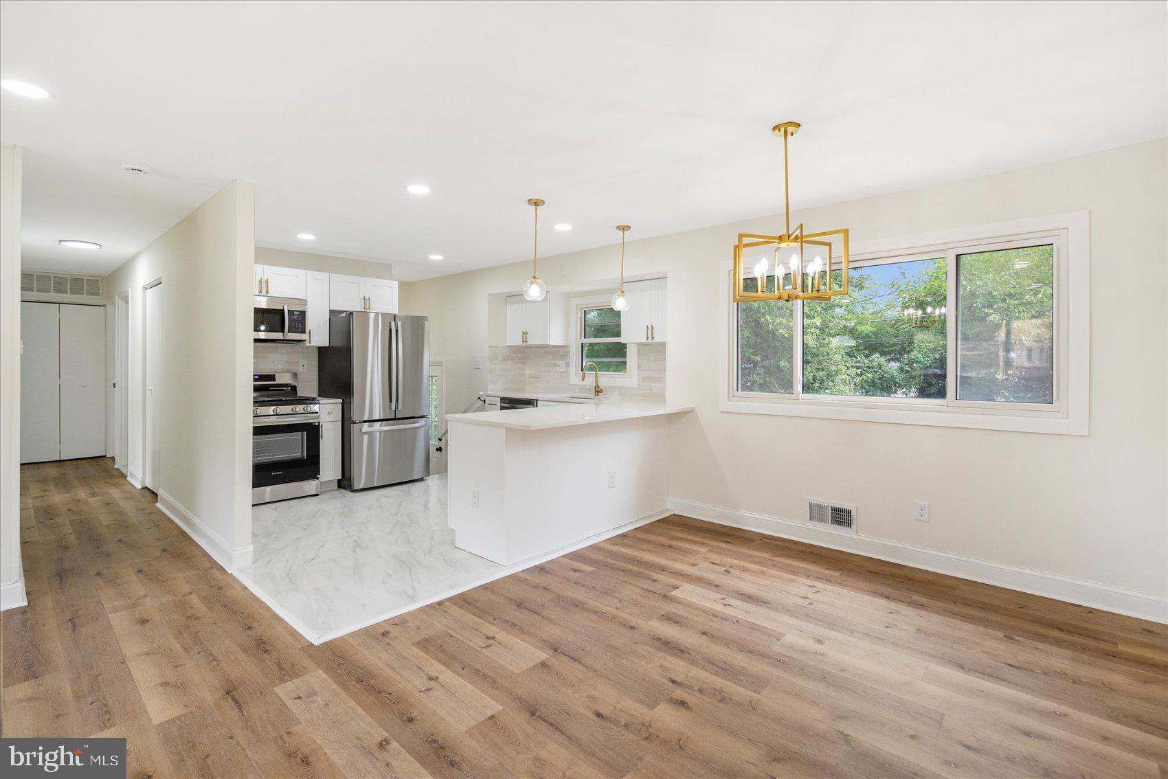 6726 Longhill Road Baltimore, MD 21207 - Photo 12 of 36 a view of a kitchen with refrigerator and wooden floor