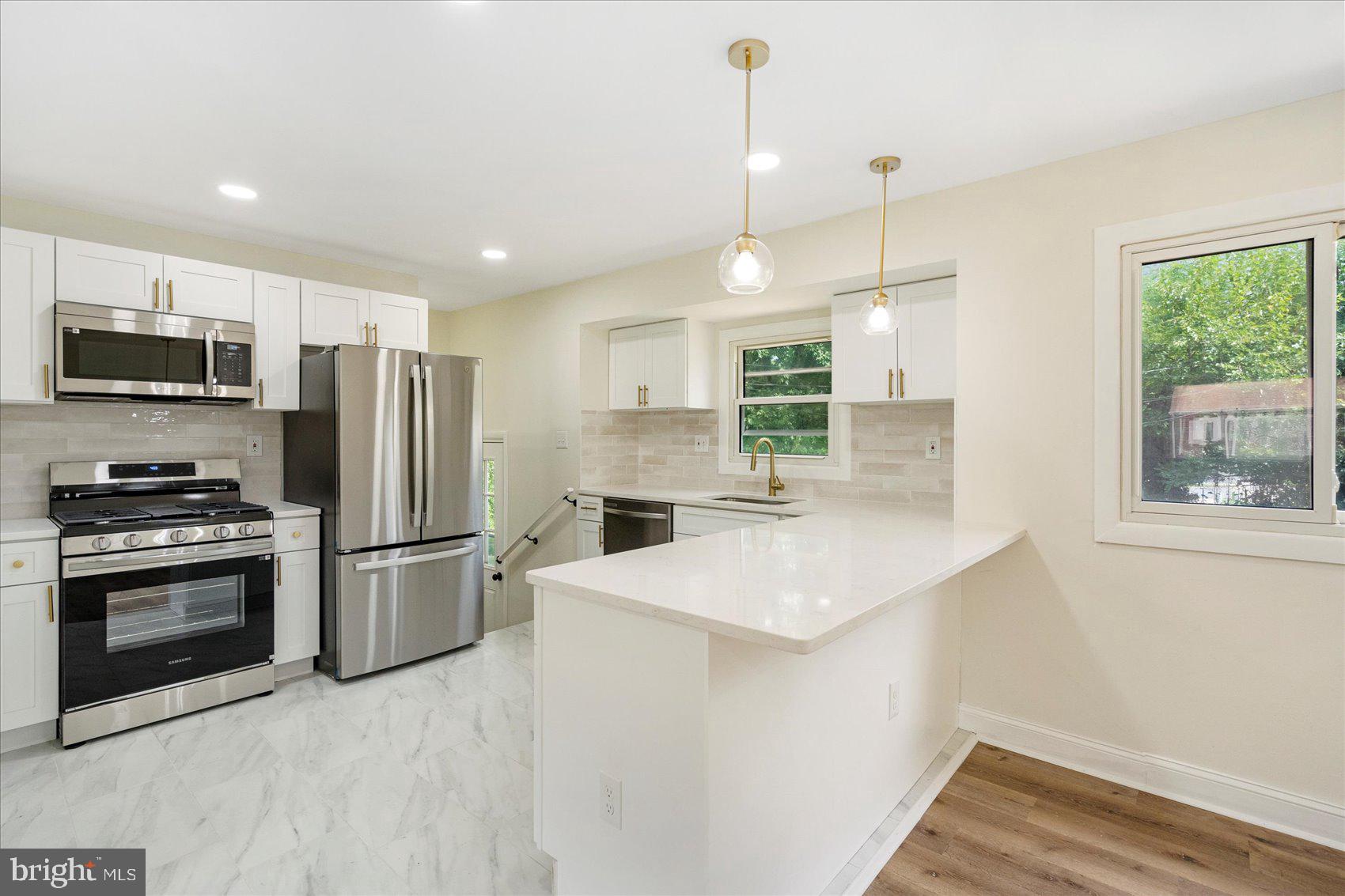 6726 Longhill Road Baltimore, MD 21207 - Photo 13 of 36 a kitchen with stainless steel appliances a refrigerator sink and microwave