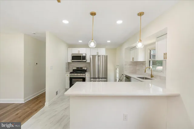 a kitchen with kitchen island a counter top space appliances and cabinets