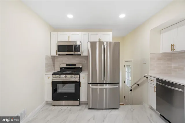a kitchen with stainless steel appliances a stove a microwave and a refrigerator
