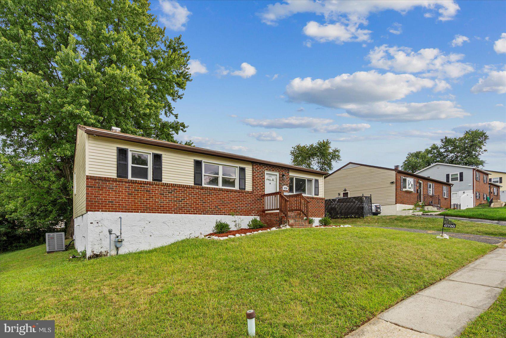 6726 Longhill Road Baltimore, MD 21207 - Photo 2 of 36 a front view of a house with a yard and trees