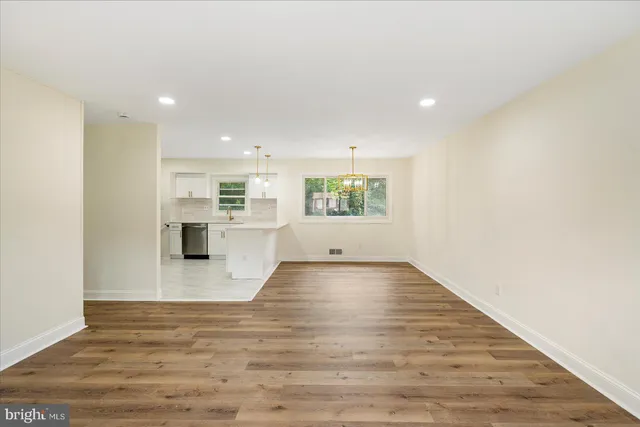 a view of empty room with wooden floor and windows