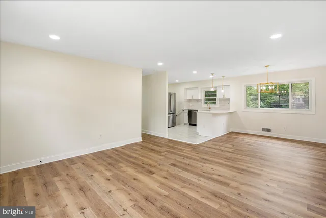 a view of empty room with wooden floor and windows