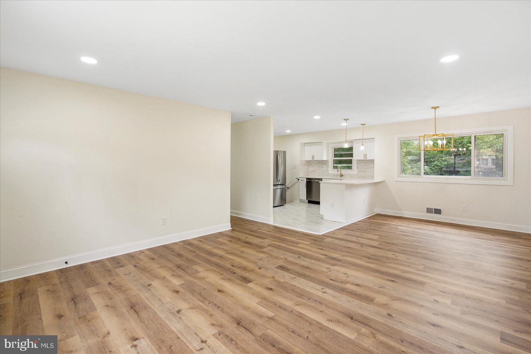 6726 Longhill Road Baltimore, MD 21207 - Photo 8 of 36 a view of empty room with wooden floor and windows