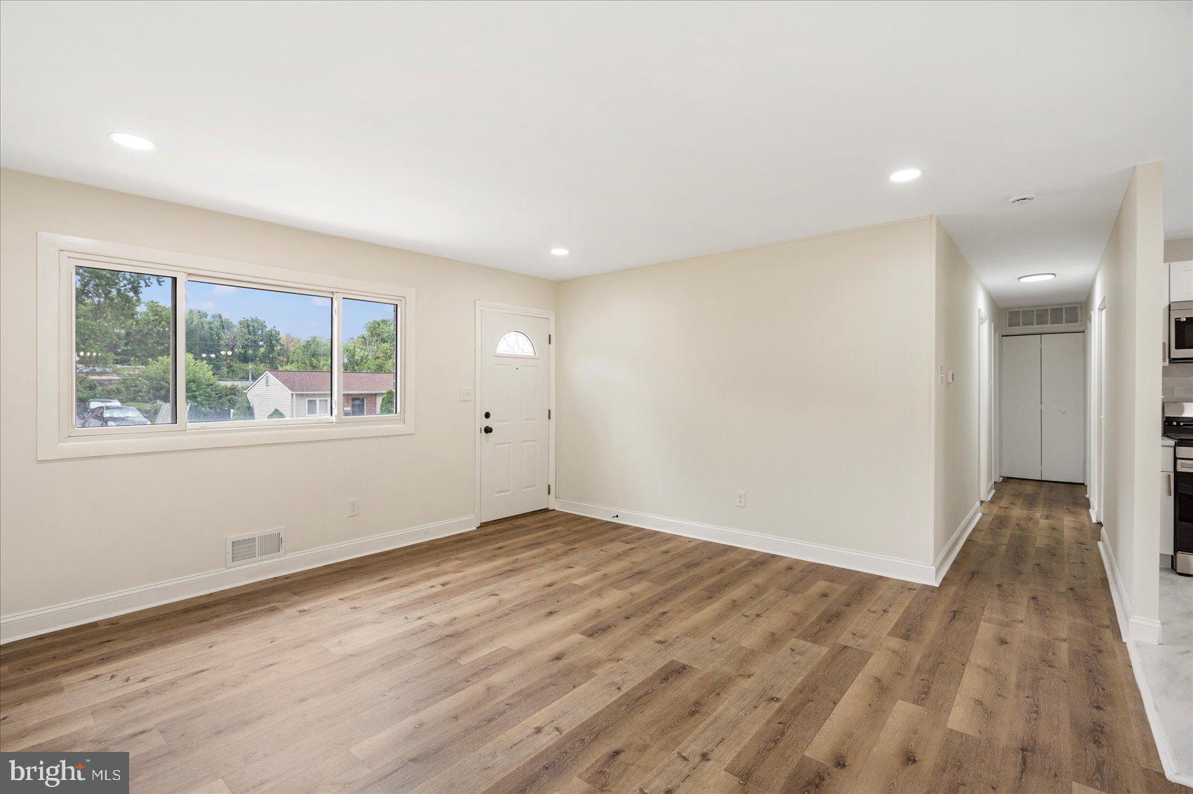 6726 Longhill Road Baltimore, MD 21207 - Photo 10 of 36 an empty room with wooden floor and windows