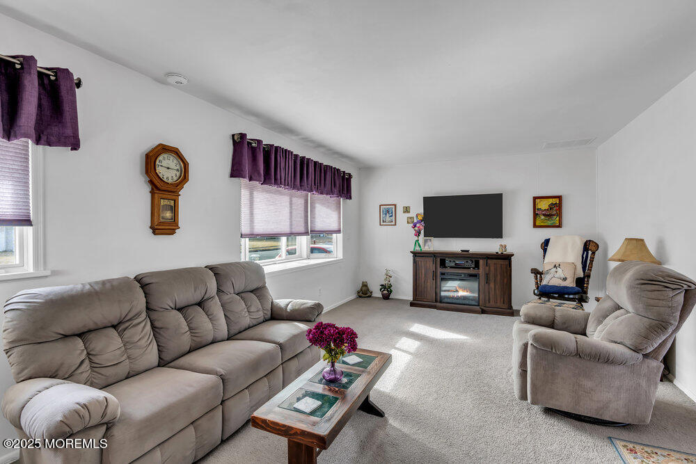 64 Sunset Drive Howell, NJ 07731 - Photo 6 of 24 a living room with furniture a fireplace and a flat screen tv