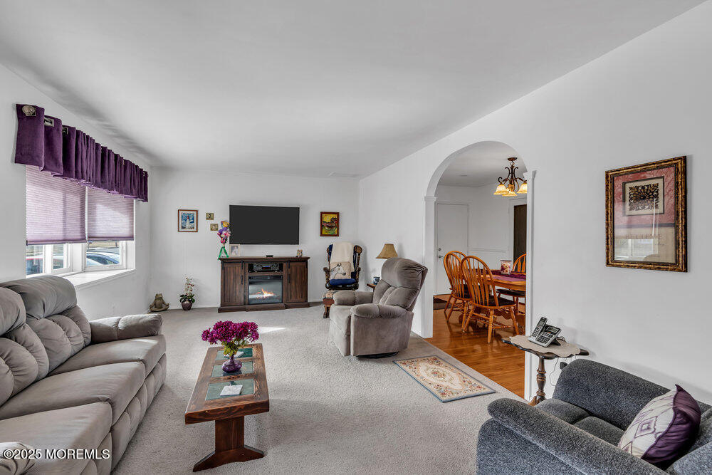 64 Sunset Drive Howell, NJ 07731 - Photo 7 of 24 a living room with furniture a fireplace and a flat screen tv