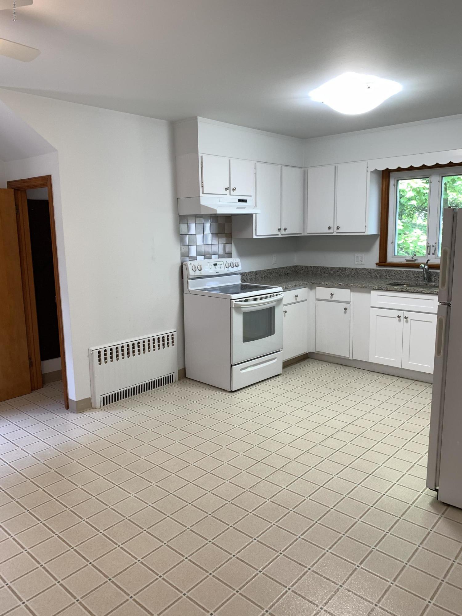 35 Sound View Drive Greenwich, CT 06830 - Photo 6 of 11 a kitchen with granite countertop white cabinets and white appliances