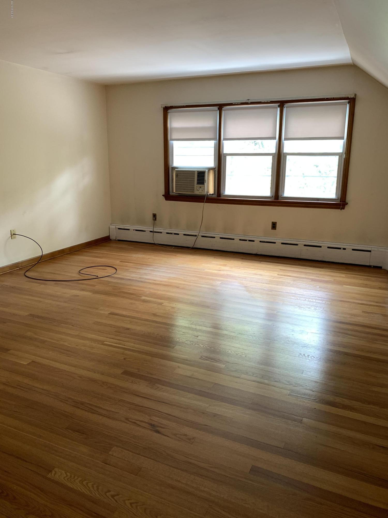 35 Sound View Drive Greenwich, CT 06830 - Photo 7 of 11 an empty room with wooden floor and windows