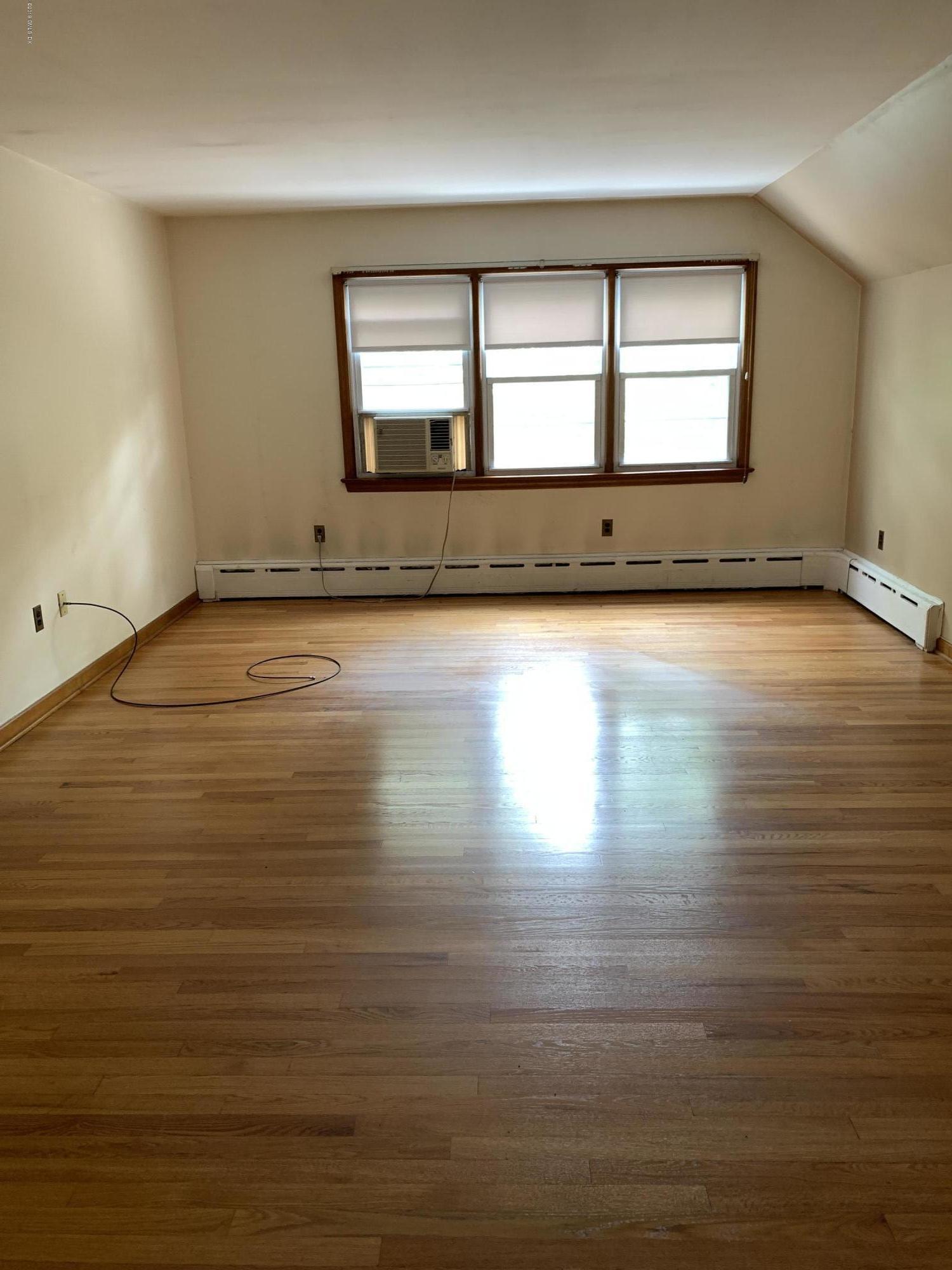 35 Sound View Drive Greenwich, CT 06830 - Photo 8 of 11 an empty room with wooden floor and windows