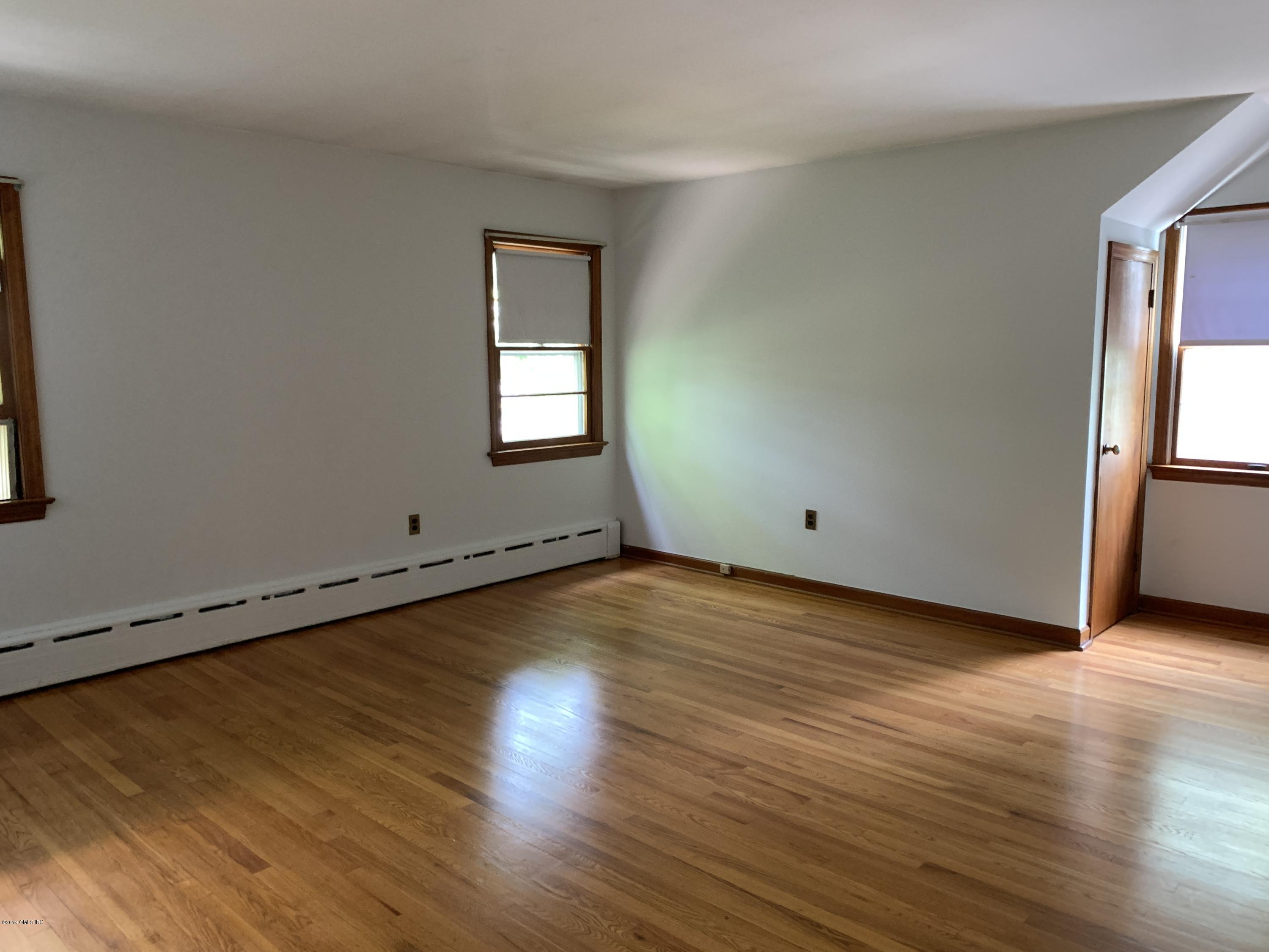 35 Sound View Drive Greenwich, CT 06830 - Photo 9 of 11 an empty room with wooden floor and windows