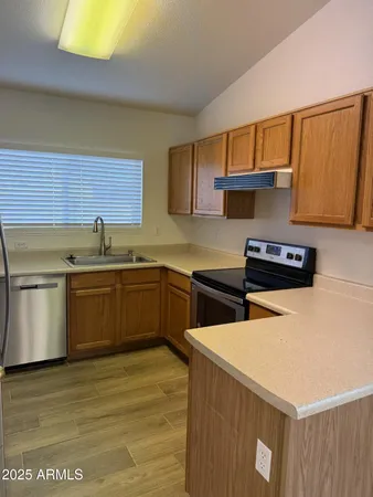 a kitchen with stainless steel appliances granite countertop a sink a stove and a refrigerator