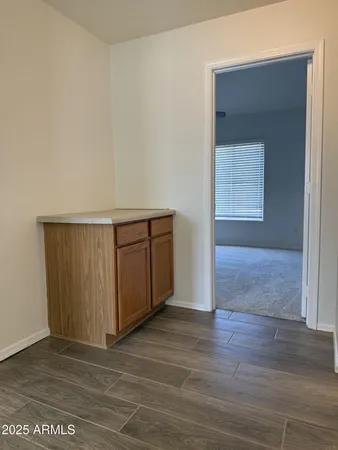 an empty room with wooden floor and cabinet
