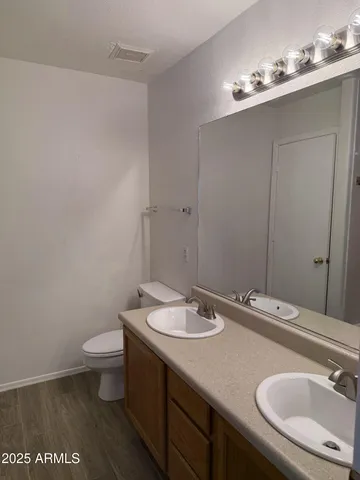 a bathroom with a sink a toilet and mirror
