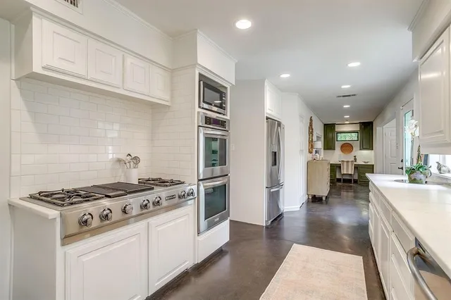 a kitchen with stove and white cabinets