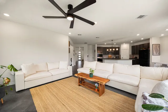 a living room with furniture and kitchen view