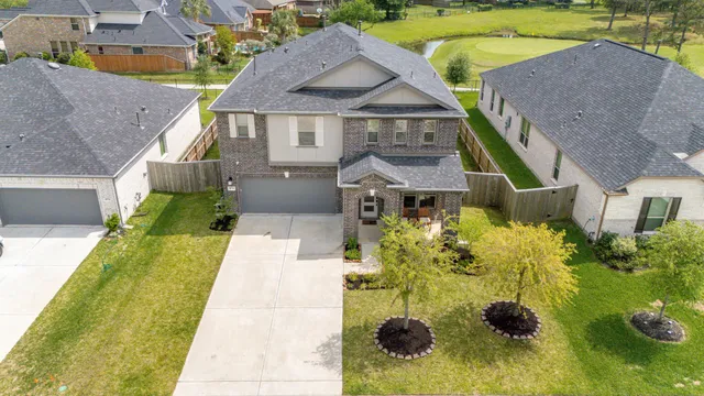a aerial view of a house with a swimming pool lawn chairs and a yard
