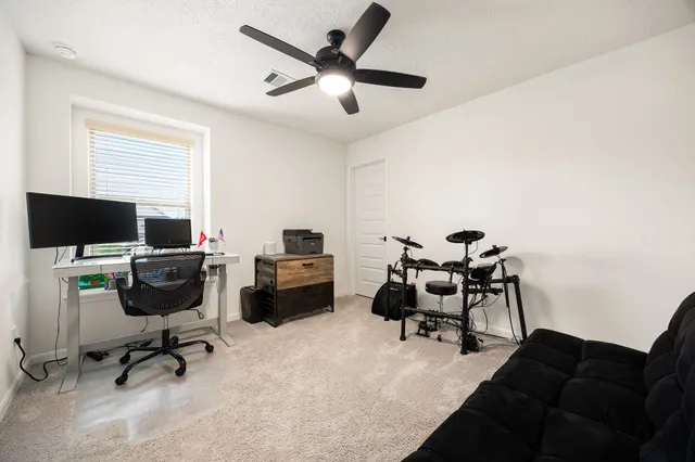 a view of a workspace with furniture and a window