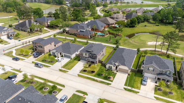an aerial view of residential houses with outdoor space and parking