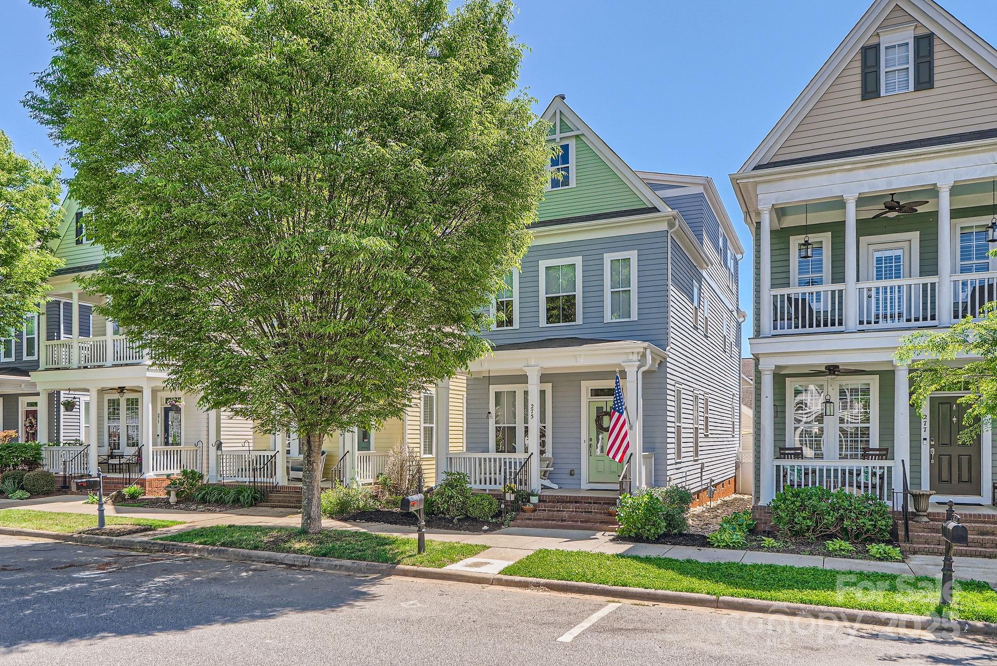 a front view of a house with garden and trees