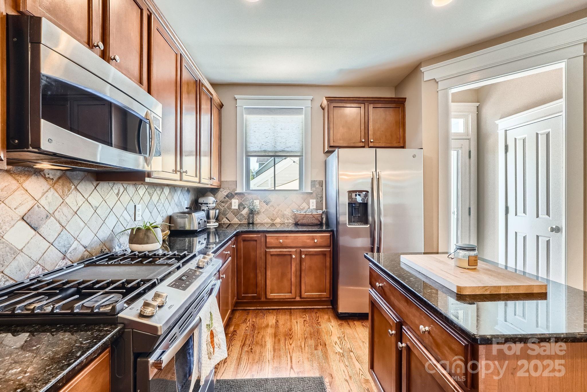 275 Bridges Farm Road Mooresville, NC 28115 - Photo 12 of 48 a kitchen with stainless steel appliances granite countertop a stove a sink and a microwave