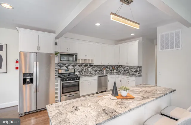 a kitchen with stainless steel appliances granite countertop a refrigerator and a stove