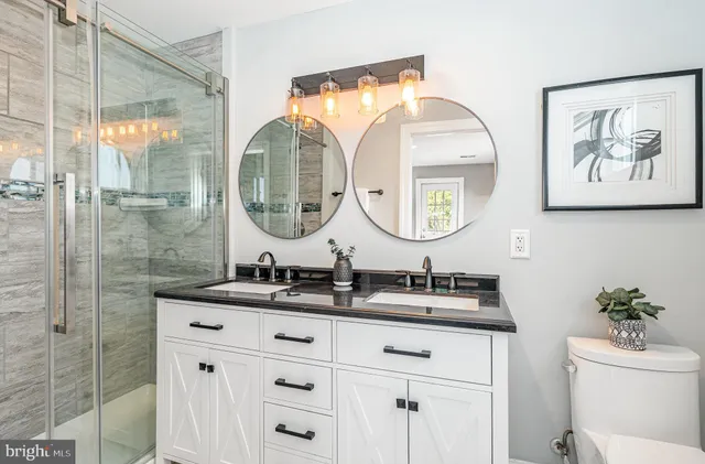 a bathroom with a double vanity sink mirror and a shower