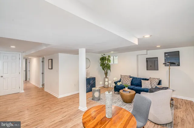 a living room with furniture a wooden floor and a flat screen tv