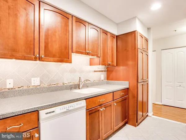 a kitchen with stainless steel appliances granite countertop a sink a refrigerator and a granite counter tops