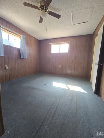 en empty room with windows and ceiling fan