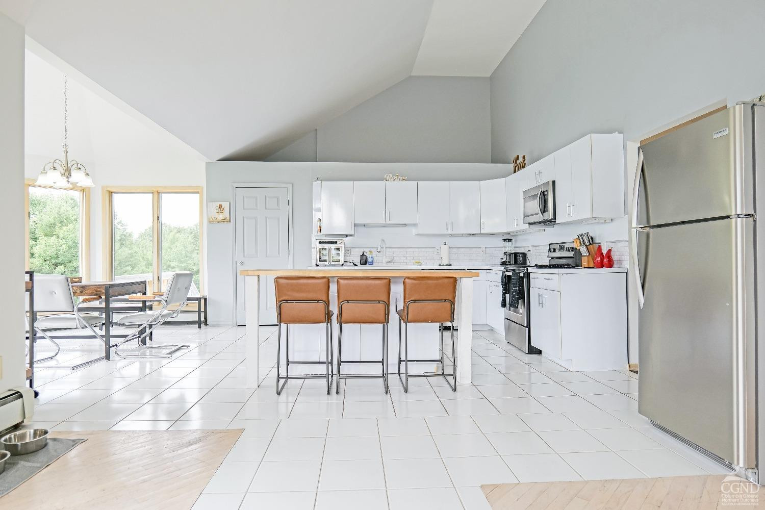 3372 County Road 10 Windham, NY 12496 - Photo 21 of 37 a kitchen with stainless steel appliances a refrigerator a stove a dining table and chairs
