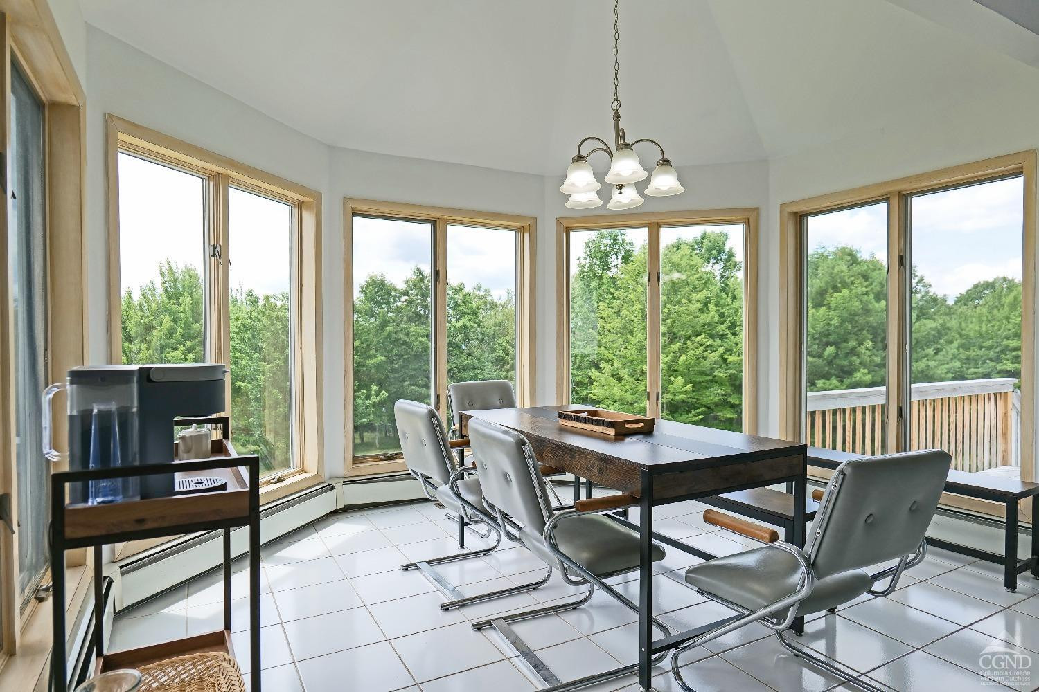 3372 County Road 10 Windham, NY 12496 - Photo 22 of 37 a dining room with furniture large windows and a chandelier