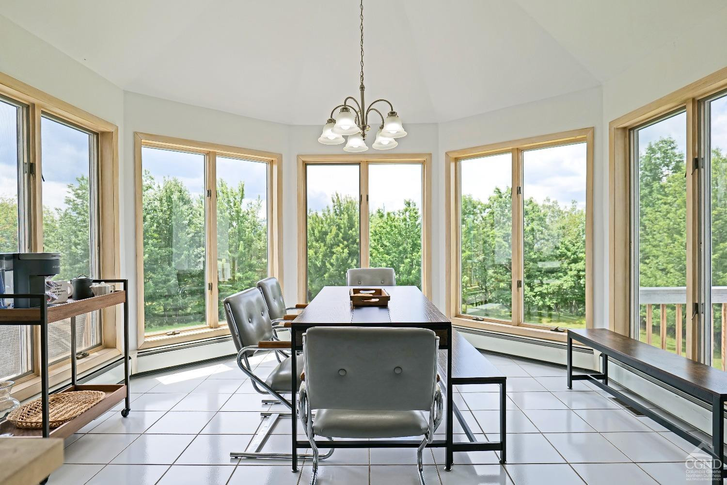 3372 County Road 10 Windham, NY 12496 - Photo 23 of 37 a dining room with furniture large windows and a chandelier