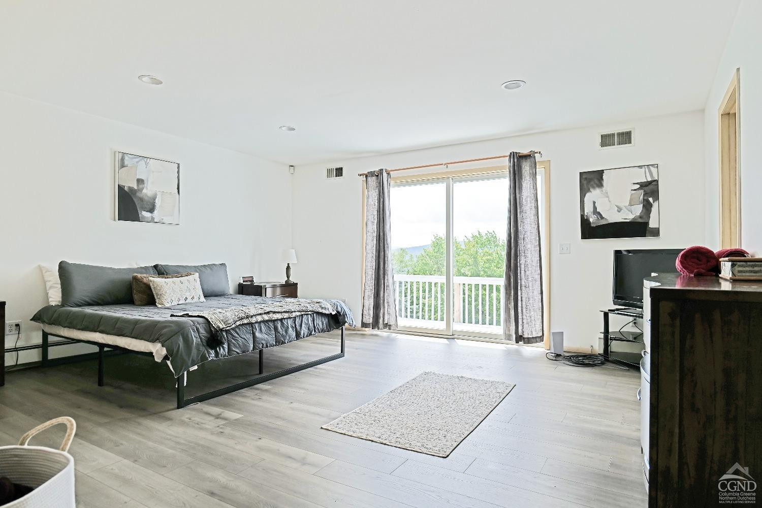 3372 County Road 10 Windham, NY 12496 - Photo 27 of 37 a spacious bedroom with a bed and a couch