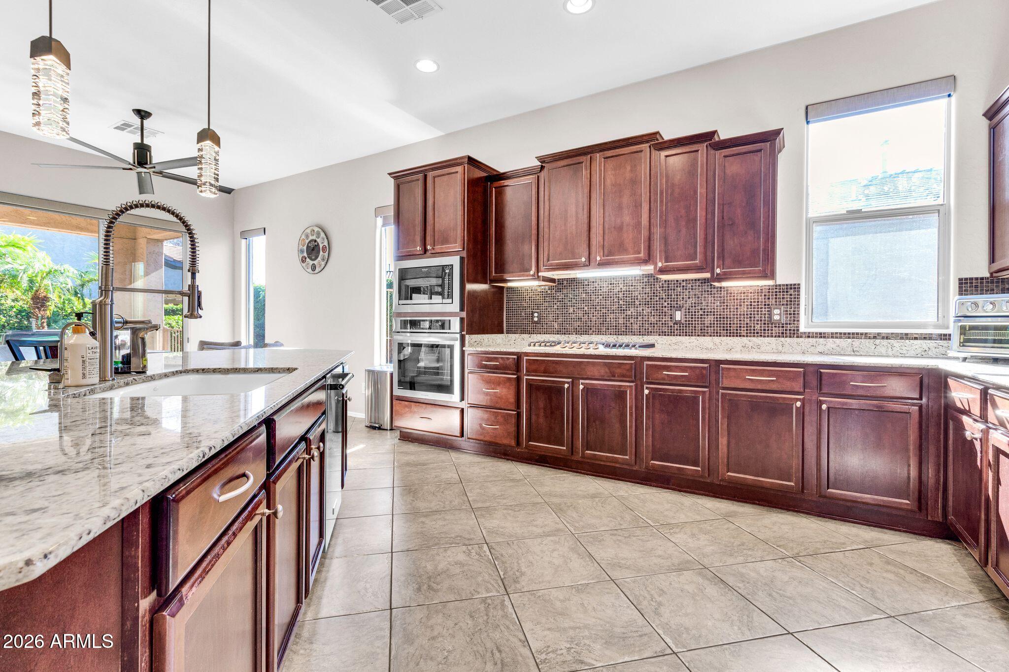 5333 South Marigold Way Gilbert, AZ 85298 - Photo 4 of 69 a kitchen with stainless steel appliances granite countertop a sink a stove counter space and cabinets