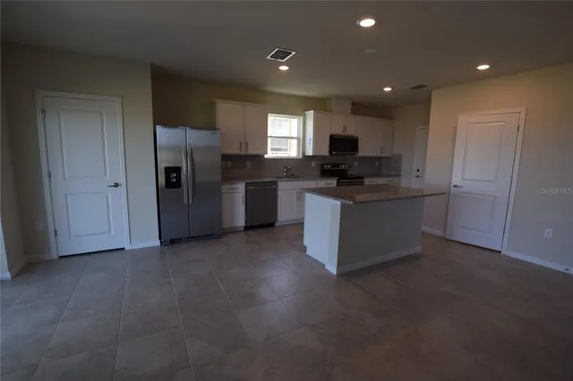 a kitchen with refrigerator and microwave