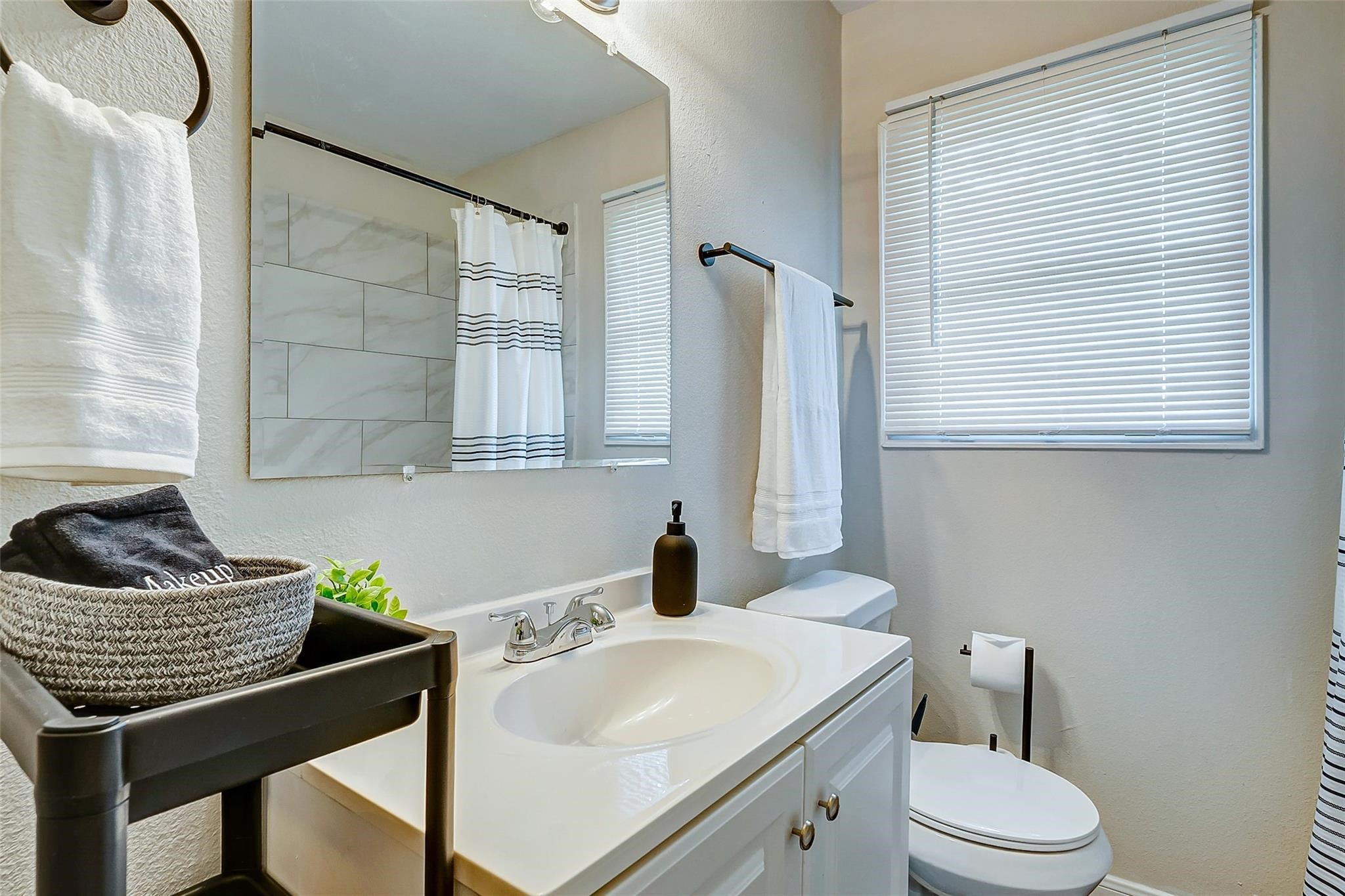 4440 Castor Street Houston, TX 77022 - Photo 11 of 30 a bathroom with a granite countertop sink toilet and mirror