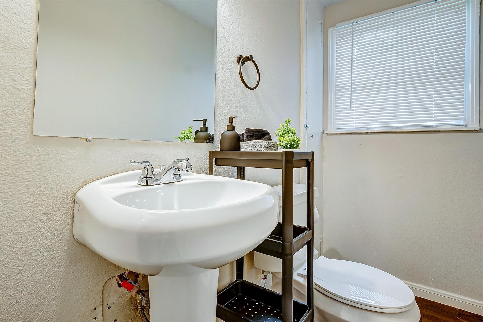 4440 Castor Street Houston, TX 77022 - Photo 17 of 30 a bathroom with a sink a toilet and a mirror