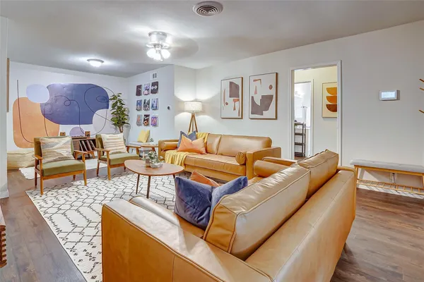a living room with furniture a wooden floor and a chandelier