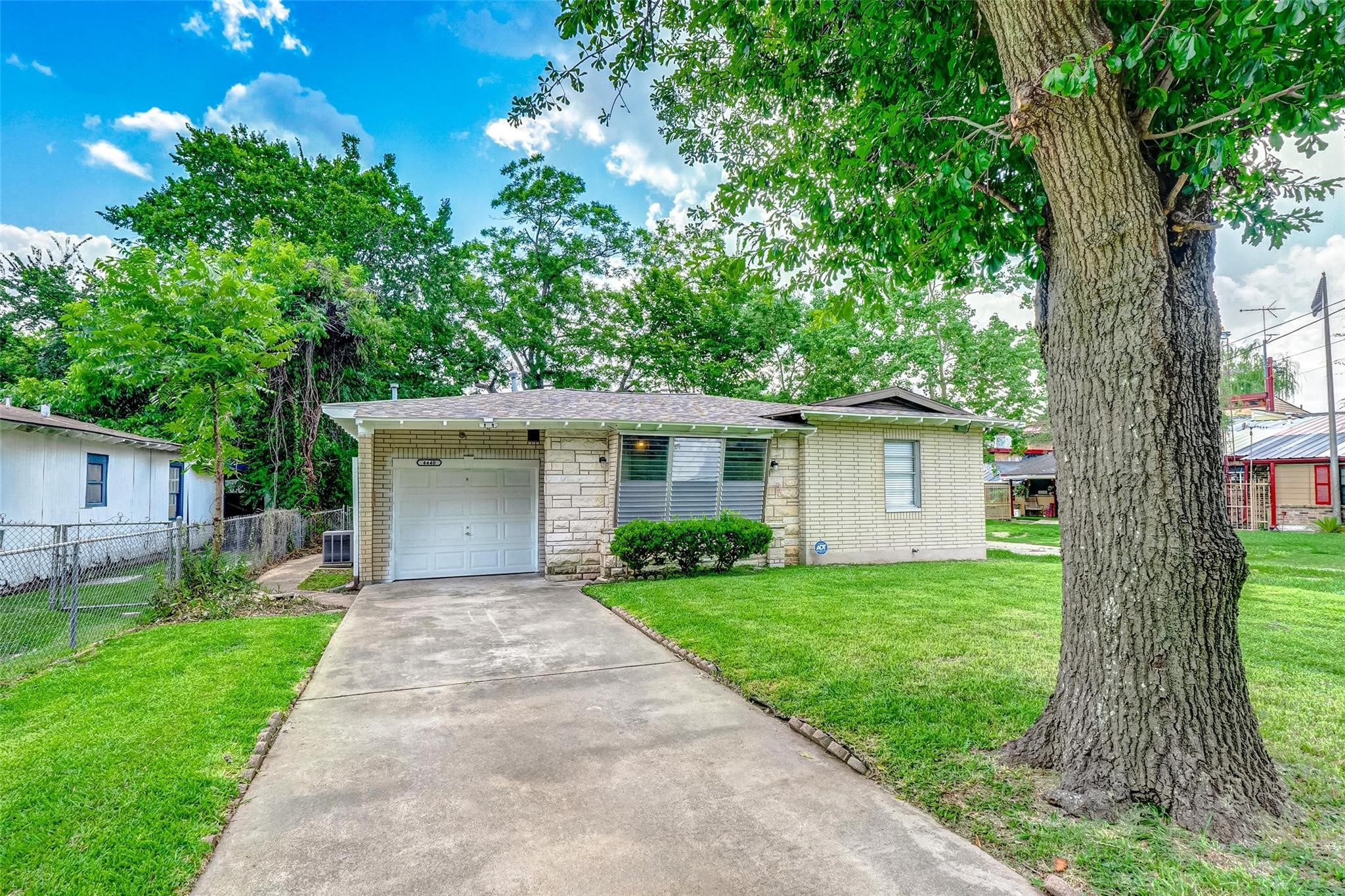 4440 Castor Street Houston, TX 77022 - Photo 27 of 30 a front view of a house with a yard and a large tree