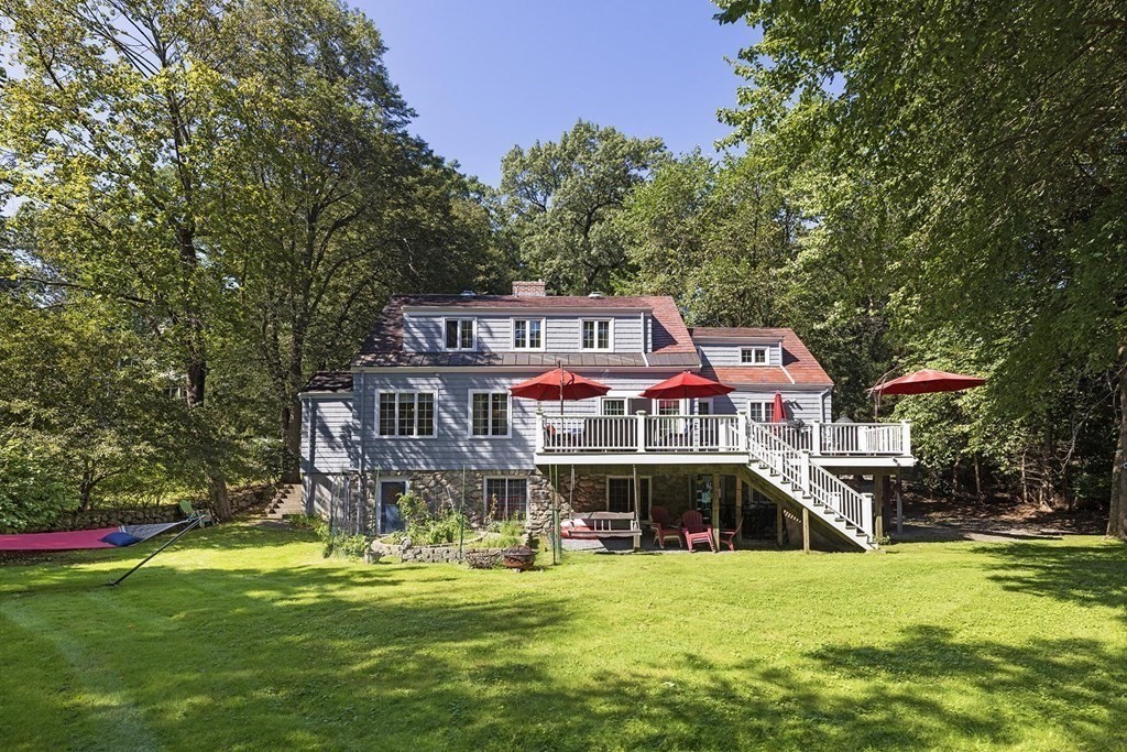 65 Rokeby Road Newton, MA 02468 - Photo 11 of 13 a sign that is sitting in front of a house with a big yard