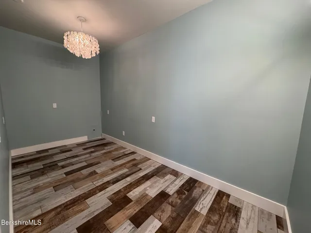 a view of a room with wooden floor