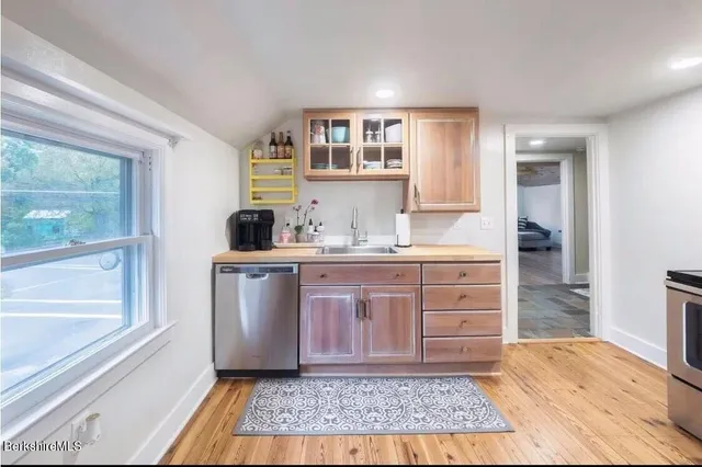 a bedroom with a large bed a flat tv screen and a dresser