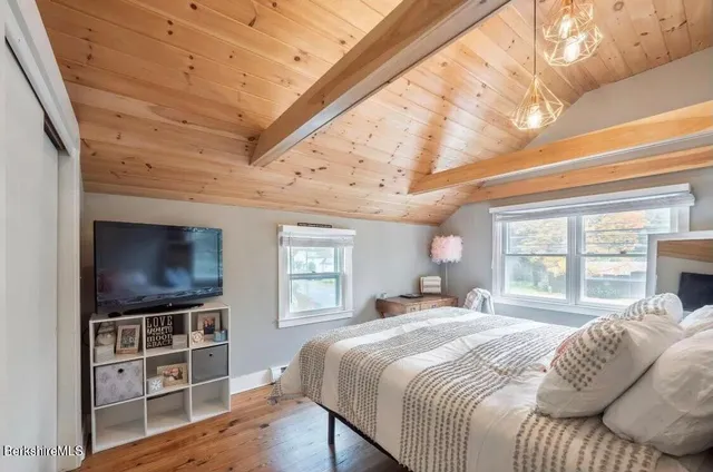 a bedroom with a bed and a wooden floor