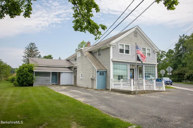 a view of a white house with a yard and plants