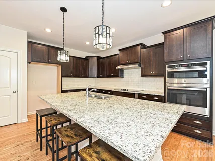 a kitchen with kitchen island granite countertop wooden cabinets and a refrigerator