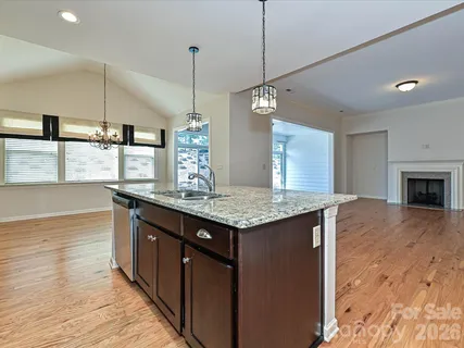 a kitchen with stainless steel appliances granite countertop a kitchen island a stove and a wooden floors