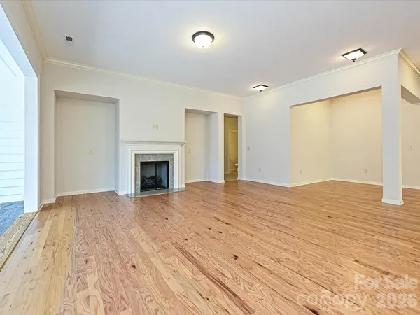 a view of empty room with wooden floor and fireplace