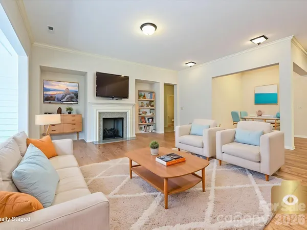a living room with furniture a flat screen tv and a fireplace