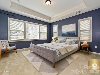 a spacious bedroom with a bed and large windows